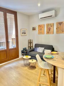 a living room with a couch and a table and chairs at Apartamento Catedral - Casco Antiguo Tarragona in Tarragona