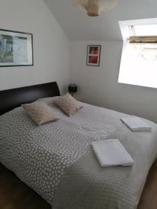 a bedroom with a bed with two pillows on it at Apt avec belle terrasse vue dégagée séjour lumineux 10 mn à pied centre Port en Bessin proche Bayeux et Omaha Beach in Port-en-Bessin-Huppain