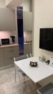 una mesa blanca y sillas en una cocina con TV en Elegant Studio, en Umag