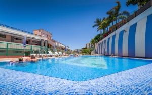 a large swimming pool with people in the water at Apartamentos las Góndolas in Playa del Ingles