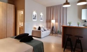 ein Schlafzimmer mit einem Bett, einem Sofa und einem Stuhl in der Unterkunft B&B Casa di Gio' in Tiggiano