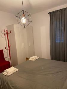 Schlafzimmer mit einem Bett und einem Kronleuchter in der Unterkunft Tranquilo piso en Cimadevilla in Gijón