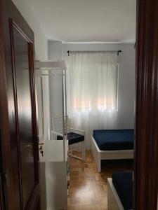 Kleines Zimmer mit einem Bett und einem Schreibtisch. in der Unterkunft Tranquilo piso en Cimadevilla in Gijón