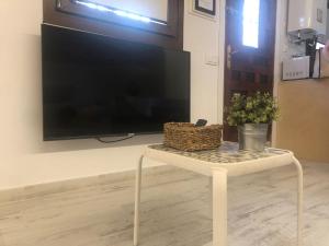 Plaza Adarve Toledo في طليطلة: غرفة معيشة مع طاولة مع تلفزيون