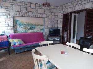 a living room with a pink couch and a table at Apartman Sole in Karigador