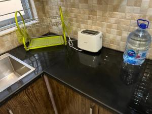 a kitchen counter with a toaster and a bottle of water at Vactional Villa Dha Phase 6 Lahore ,Three Bed Room Full House in Lahore +107 photos