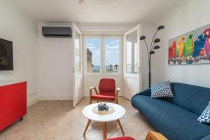 a living room with a blue couch and a red chair at Bella Vista KTH in Trogir