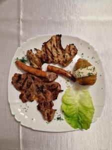 PENSIUNEA ADA في Bascov: طبق من الطعام مع اللحوم والخضروات على الطاولة