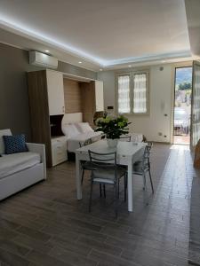 een woonkamer met een tafel en stoelen en een slaapkamer bij Monolocale da Andrea in Custonaci
