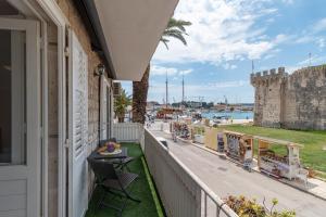 a balcony with a view of the ocean and a castle at Bella Vista KTH in Trogir