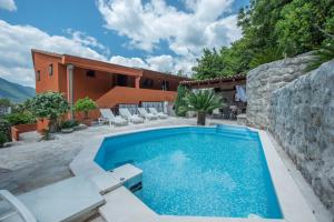a swimming pool in a yard with a house at Apartments Nikčević in Kotor