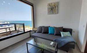 salon z kanapą i szklanym stołem w obiekcie Aloha Beach Vibe w mieście Benalmádena