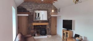 a living room with a stone fireplace and a television at Stonehaven 2 Bedroom Seaside Cottage with Garden in Stonehaven