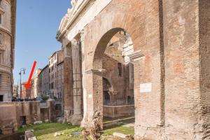 an old brick building with an arch in a street at Bilocale nel cuore del quartiere ebraico in Rome