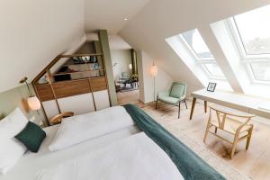 a bedroom with a bed and a desk and a chair at Hotel Astra Maris in Büsum