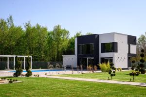 a house with a swimming pool in front of a yard at Villa Hills in Bijeljina