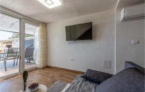 a living room with a couch and a tv on the wall at Lovely Apartment In Petrcane With Wifi in Petrcane