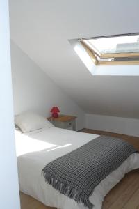 Un dormitorio blanco con una cama y un tragaluz. en Porte de Paris, en Montesson