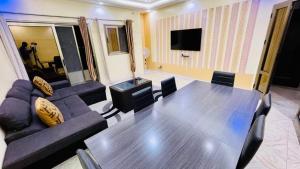 a conference room with a table and chairs and a tv at JIKKE Appartement in Dakar