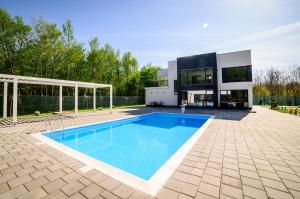 a villa with a swimming pool in front of a house at Villa Hills in Bijeljina