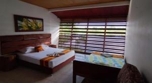 a bedroom with two beds and a large window at Reserva Yavary Tucano in Leticia