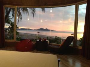 a bedroom with a bed and a view of the ocean at Ban Tawansongfa in Lang Suan