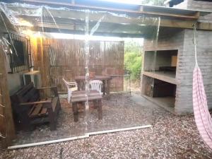 a patio with a table and chairs and a fireplace at Gotas de Rocio in Piriápolis