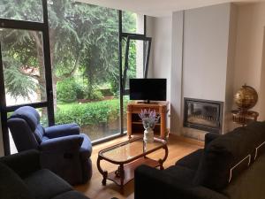sala de estar con 2 sofás, mesa y TV en Casa do Corredor, en Chantada