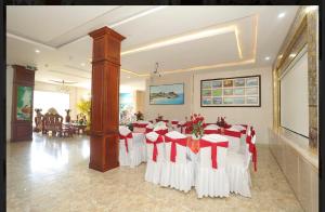 una sala banchetti con tavolo con sedie rosse e bianche di Kim Ngoc Khanh Hotel a Tuy Hoa