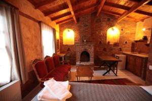 una sala de estar con chimenea y una habitación con cama en Kayserkaya Cottages, en Selçuk