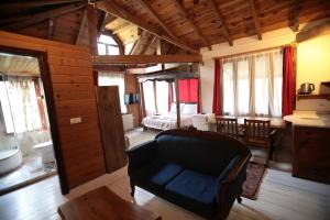 un salon avec un canapé bleu et une chambre dans l'établissement Kayserkaya Cottages, à Selçuk