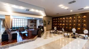 un vestíbulo con una sala de espera con mesas y sillas en Elpida Resort & Spa, en Serres