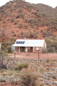 a house with solar panels on the side of a hill at Nudlamutana Hut - Vulkathunha-Gammon Ranges National Park in Arkaroola