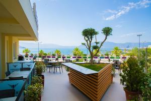 Un patio con mesas y sillas y vista al mar. en Veranda Boutique Hotel, en Vlorë