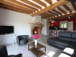 a living room with a couch and a fireplace at Gîte Juvigny-Val-d'Andaine, 5 pièces, 9 personnes - FR-1-497-115 in Saint-Denis-de-Villenette