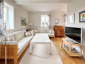 Holiday home YNGSJÖ, SVERIGE II في Yngsjö: غرفة معيشة مع أريكة بيضاء وتلفزيون
