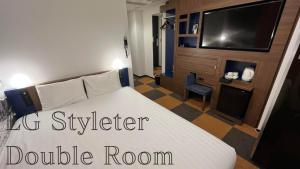 a hotel room with a bed and a tv at Henn na Hotel Tokyo Haneda in Tokyo
