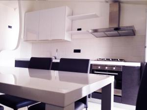 a kitchen with a white table and black appliances at La Vallata B&B in Sardegna in Ghilarza