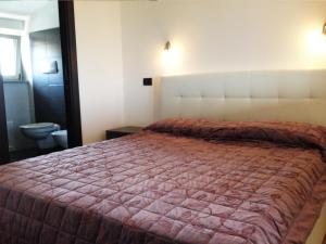 um quarto com uma cama grande e um cobertor vermelho em La Vallata B&B in Sardegna em Ghilarza