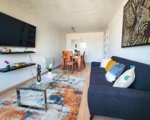uma sala de estar com um sofá azul e uma mesa em Departamento familiar en plan de Viña del Mar em Viña del Mar