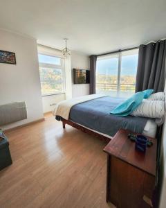 a bedroom with a bed and a large window at Departamento familiar en plan de Viña del Mar in Viña del Mar