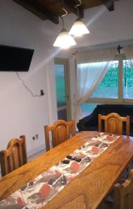 ein Esszimmer mit einem Holztisch mit Stühlen und einem Fenster in der Unterkunft Departamento FAMILY in Mendoza