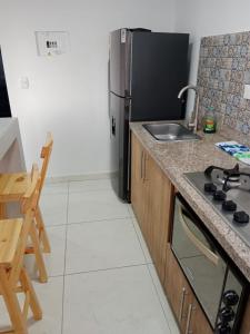 y cocina con fogones y nevera. en Apartamento vacacional amoblado, en Armenia