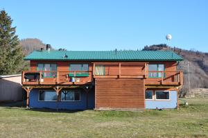 a wooden house with a green roof at Homerhome in Homer