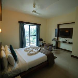 a bedroom with a large bed with a large window at Vari Park - Comfort Stay in Dindigul