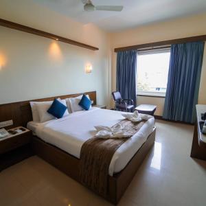 a hotel room with a large bed and a window at Vari Park - Comfort Stay in Dindigul