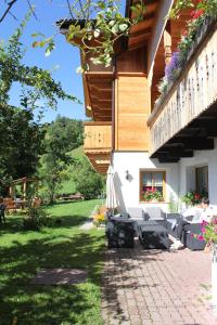 a patio of a house with some chairs and a table at B&B Ciasa Brüscia in San Vigilio Di Marebbe