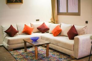 un soggiorno con divano e cuscini sopra di Issli appartment ad Azrou