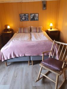 a bed in a room with a chair and a bed sidx sidx sidx at Handelsstedet Forvik in Vevelstad