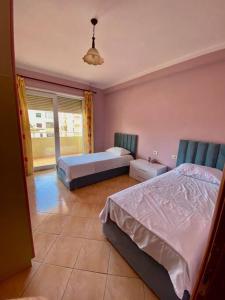 a bedroom with two beds and a window at Family friendly 2-bedroom apartment in Durres :) in Durrës